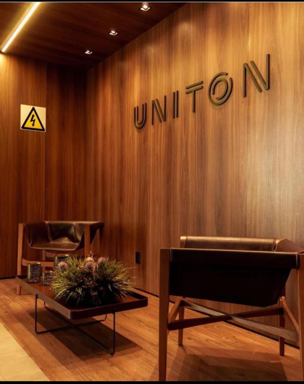 Hall do Edifício Uniton com poltronas e acabamento em madeira